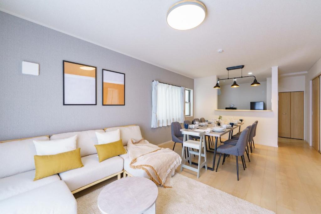 ein Wohnzimmer mit Couch und ein Esszimmer in der Unterkunft Nagoya15min 6 beds Free Parking 3BR 13guests 100sqm in Nagoya