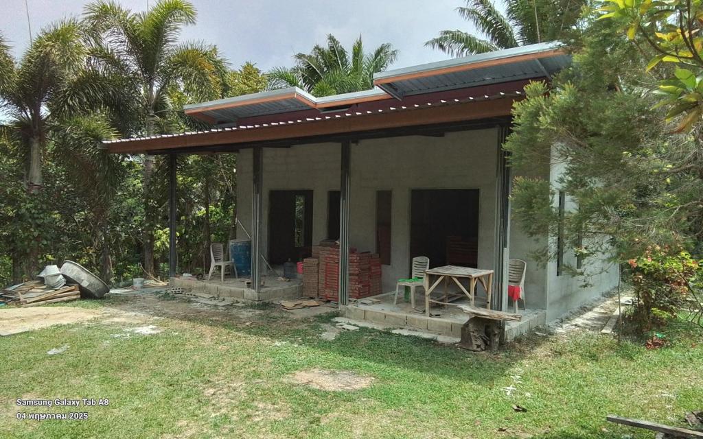 a small house with a porch and two chairs at Lanta Vacation House in Ko Lanta Yai