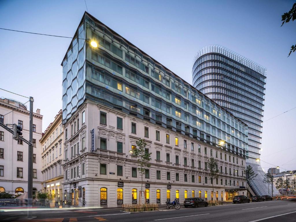 a tall building on a city street with a building at Novotel Wien City in Vienna