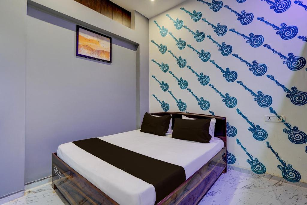 a bedroom with a bed with a blue wall at SPOT ON Surya Hotel in Handiā