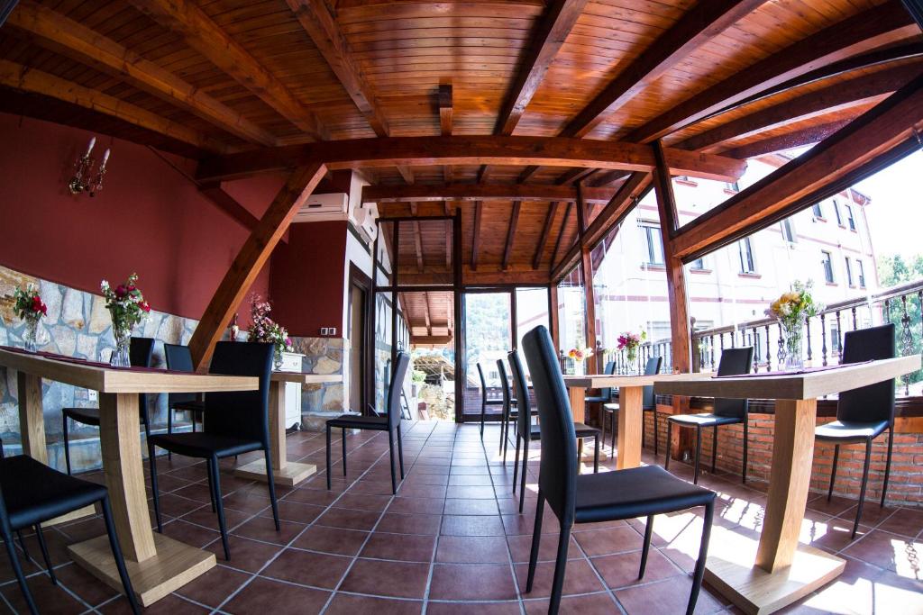 a restaurant with wooden ceilings and tables and chairs at Hotel Mariñerune in Mungia