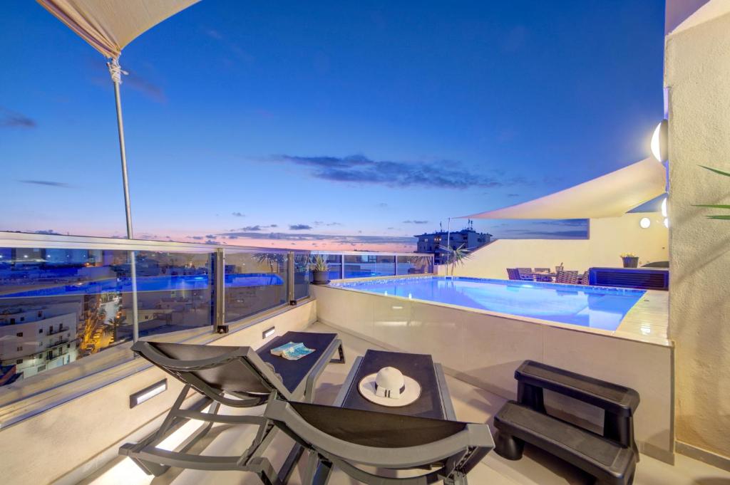 a balcony with a pool and a table and chairs at D Top View in St. Paul's Bay