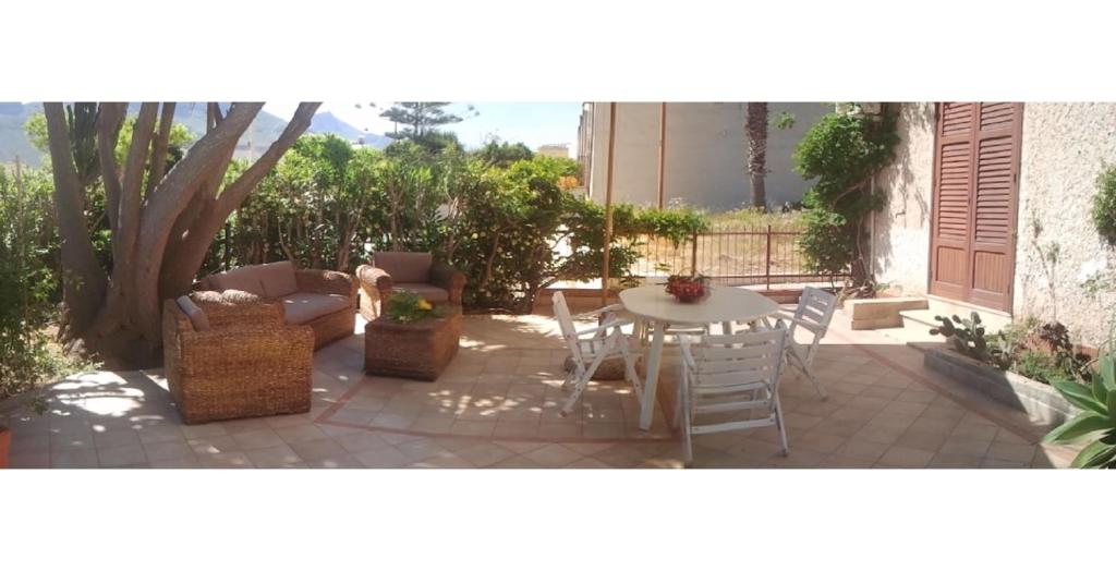 a patio with a table and chairs and a tree at Casa Giummarra in San Vito lo Capo