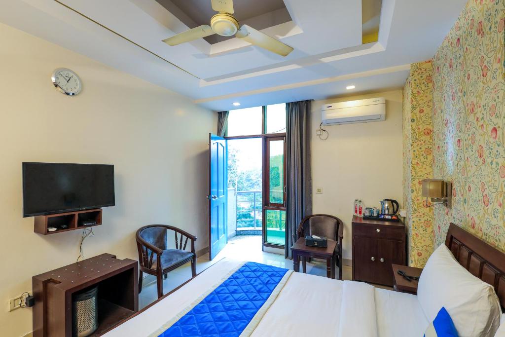 a bedroom with a bed and a tv and a room at Nikko Blue - Boutique Hotel in Gurgaon