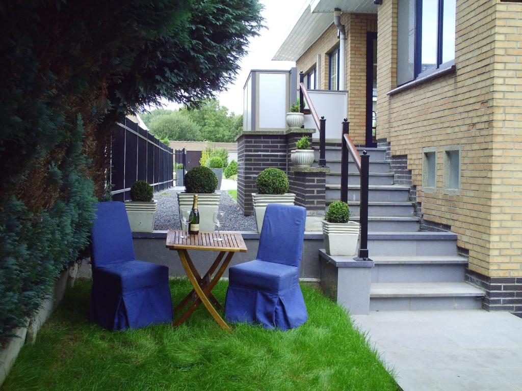 尼諾弗的住宿－卡皮塔爾公寓，庭院设有2把蓝色椅子、桌子和楼梯