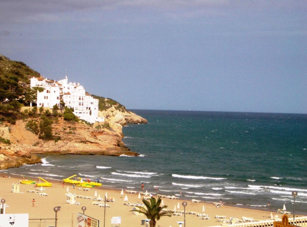 a group of people on a beach near the ocean at Sitges Beach Loft in Sitges