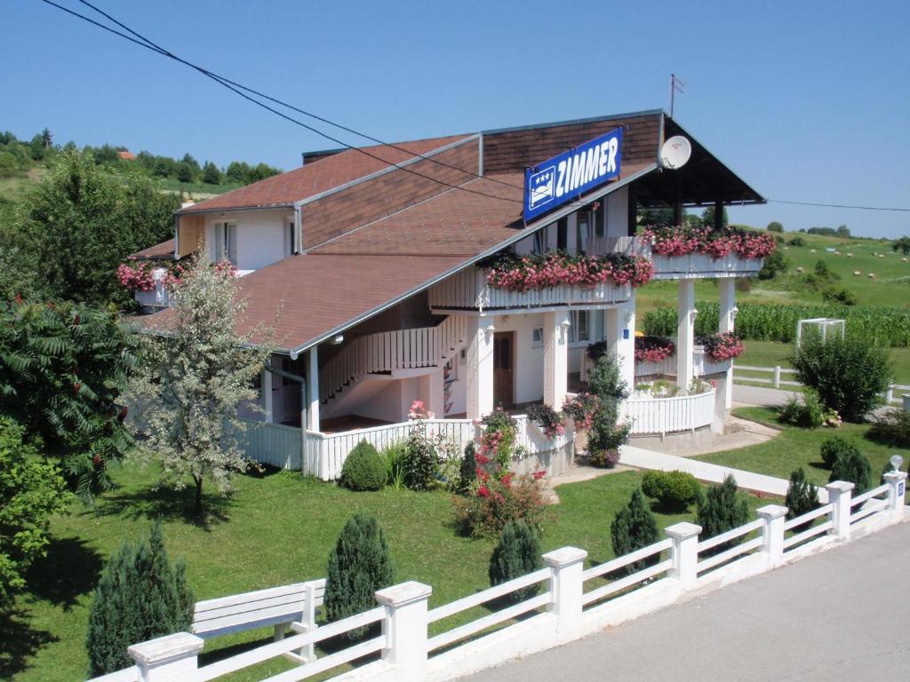 a white house with a sign on the front of it at House Zupan in Rakovica