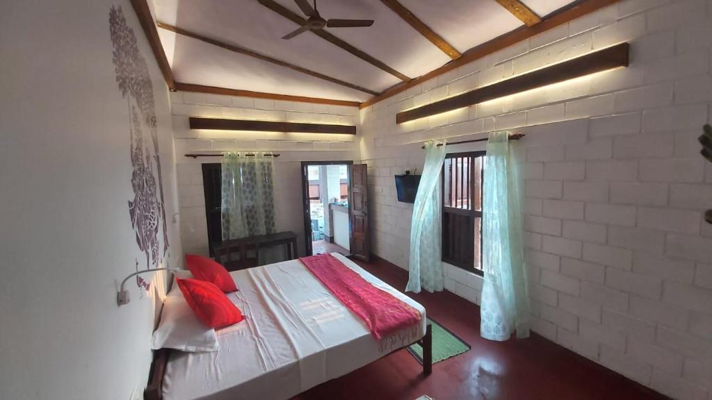 ein Schlafzimmer mit einem Bett mit roten Kissen darauf in der Unterkunft 36 Palms Heritage Villa in Kochi