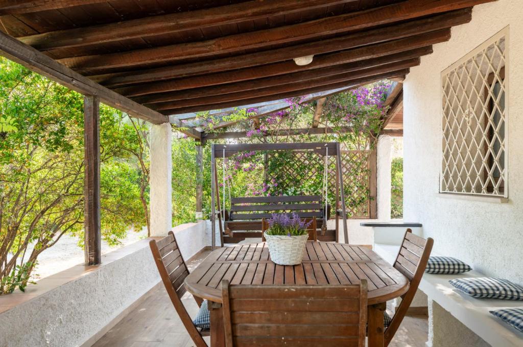 a wooden table and chairs on a patio at Villa Olivastro by Klodge in Olbia