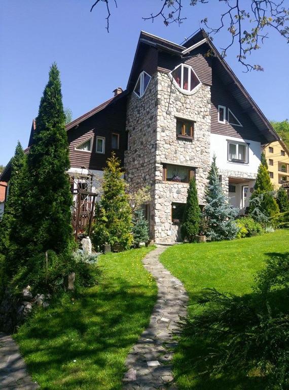 a large stone house with a pathway in front of it at Pension Casa Contelui in Râşnov