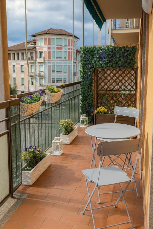 a patio with a table and chairs on a balcony at Beautiful floral apartment on Navigli in Milan