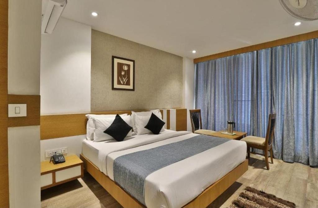a hotel room with a bed and a large window at Lemon tree premier in Mandsaur