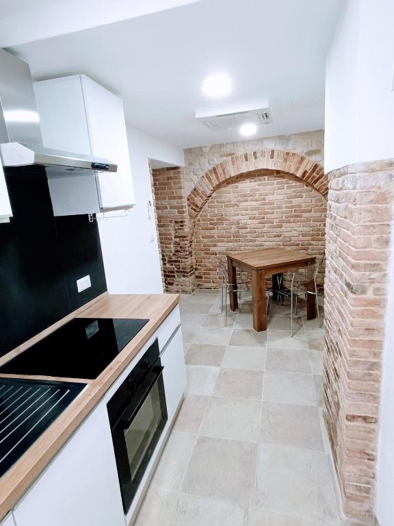 a kitchen with a table and a brick wall at Il rifugio del tempo - Domus Marconi in Campobasso