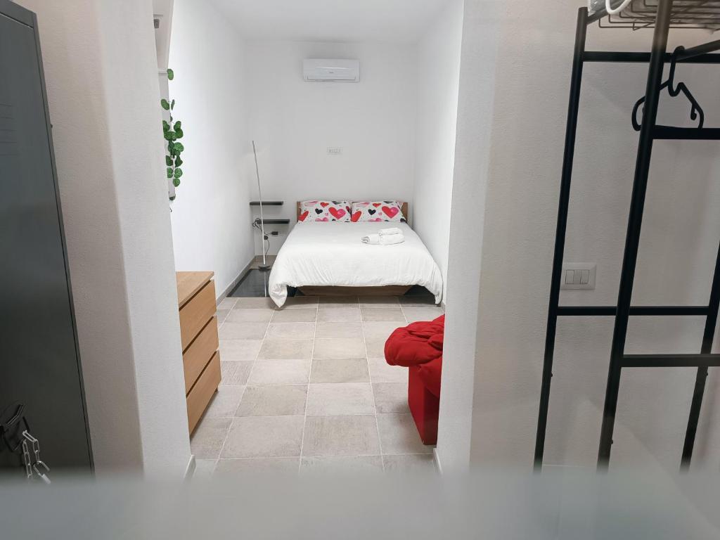 een kleine kamer met een bed en een rode bank bij Domus Marconi in Campobasso