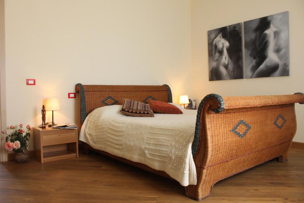 - une chambre avec un lit avec une tête de lit en osier et 2 lampes dans l'établissement Casale La Barca, à Albinia