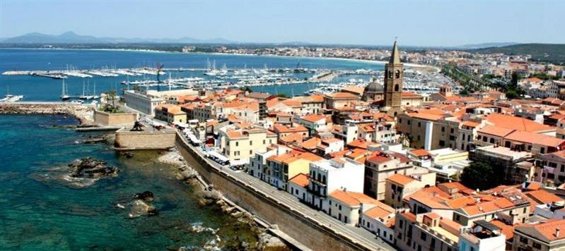 une ville avec un port et des bateaux dans l'eau dans l'établissement Alghero Tour, à Alghero