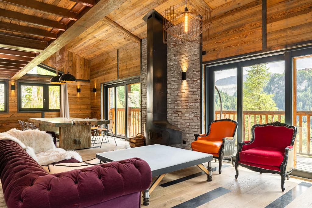 sala de estar con sofá, sillas y chimenea en Black Diamond - Chalet Bansky, en Les Brévières
