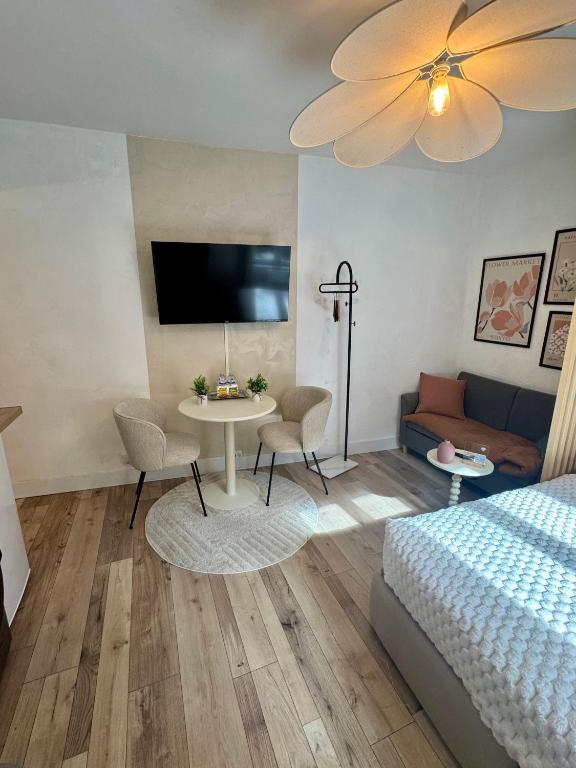 a bedroom with a bed and a table and a couch at Le Nid du Rez in Amiens