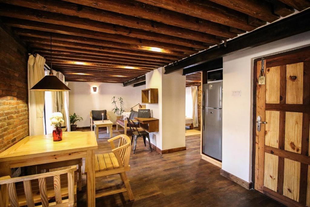 a kitchen and dining room with a table and a door at Balcony apartment- 50m from Patan Durbar Sq in Pātan