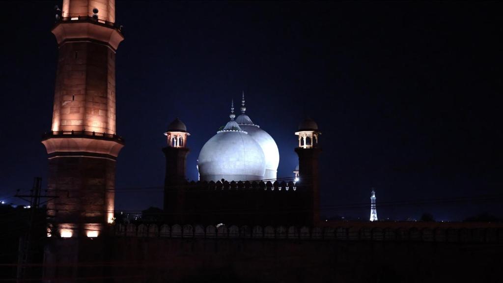 Un edificio iluminado con dos torres por la noche. en CityLife Lahore Boutique Heritage Home In Walled City, en Lahore