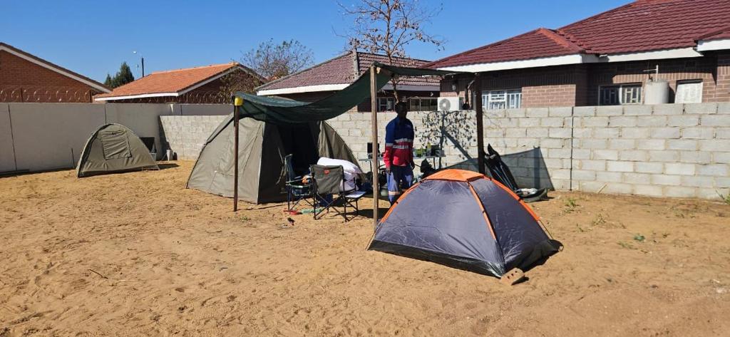 a group of tents sitting in a dirt yard at The Kimberlite Camping & Caravan Parking, Jwaneng in Jwaneng
