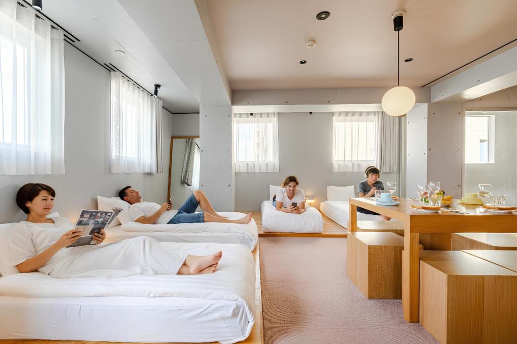 a group of people sitting on couches in a living room at STAY ARI Apartment Hotel Shinjuku-Takadanobaba in Tokyo