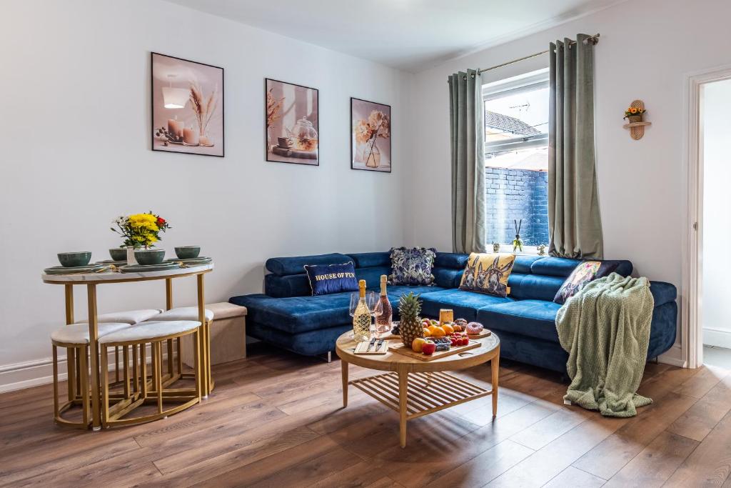 a living room with a blue couch and a table at 5BR - House - Hot Tube - Airport - A38-A50 - Parking in Burton upon Trent