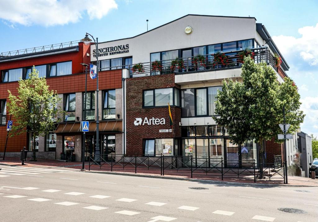 a building on the corner of a street at Hotel Sinchronas in Telšiai