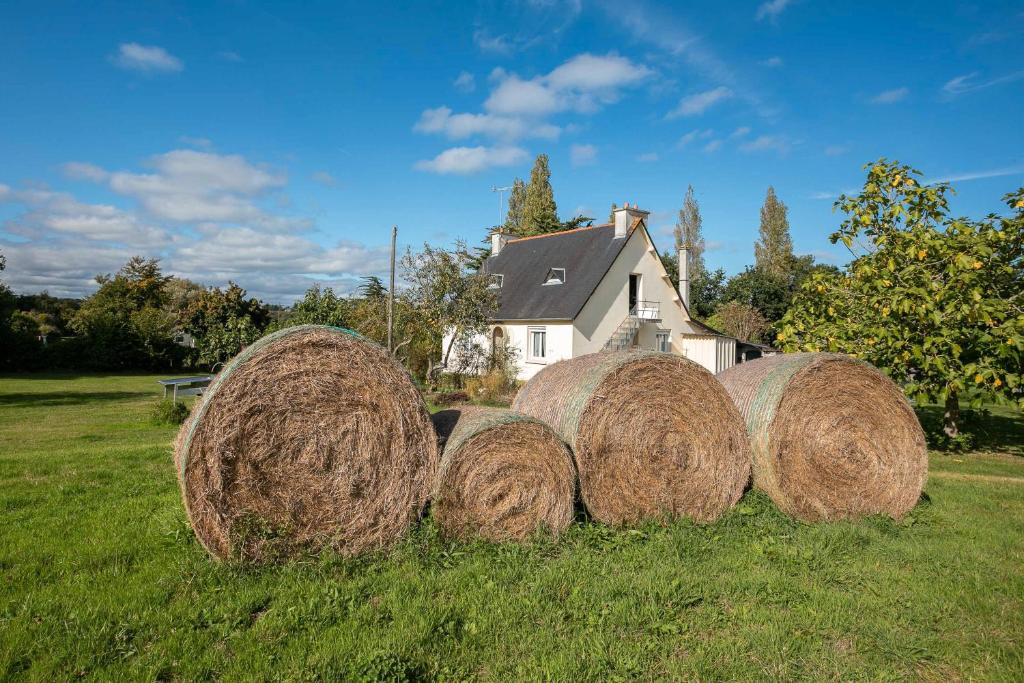 un groupe de balles de foin dans un champ devant une maison dans l'établissement Maison Plouha proche plage, à Plouha