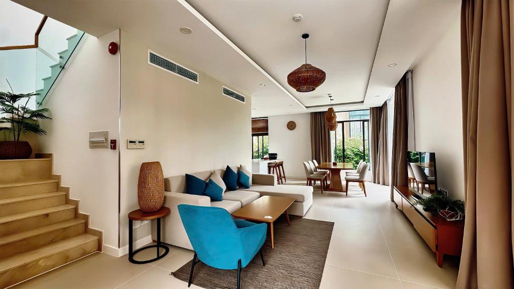 a living room with a white couch and blue chairs at Alexa Villa Cam Ranh - 3 Bedrooms, Private Pool, Beach Access in Cam Lâm