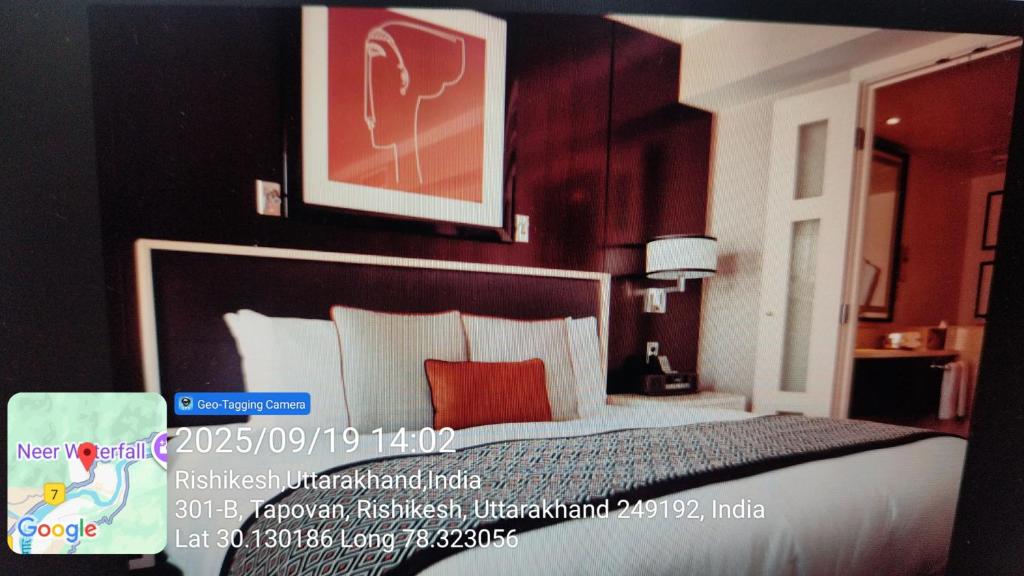 a hotel room with a bed with red and white pillows at Hotel Kavya in Rishīkesh