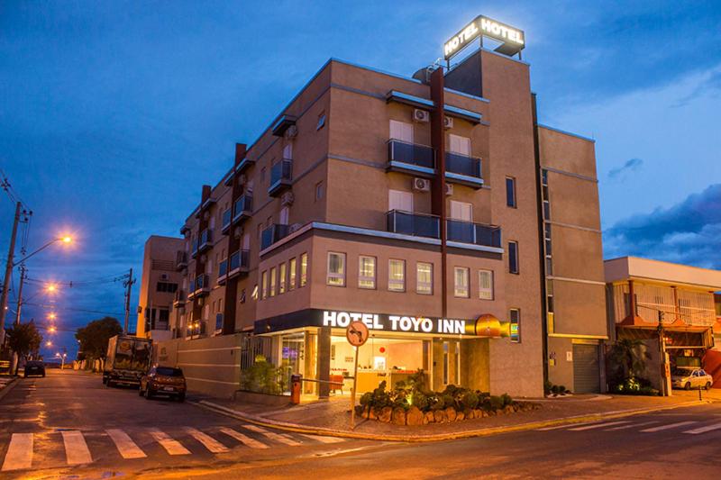 a hotel room inn on a city street at night at Hotel Toyo Inn in Boituva