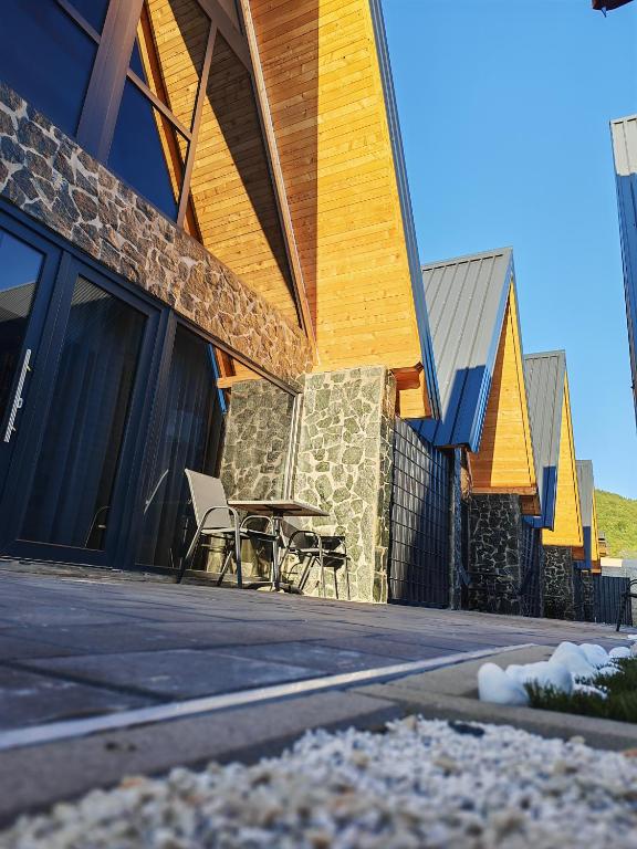 a building with a patio with a table and chairs at Bungalov Damiano's 9 in Podbrdo