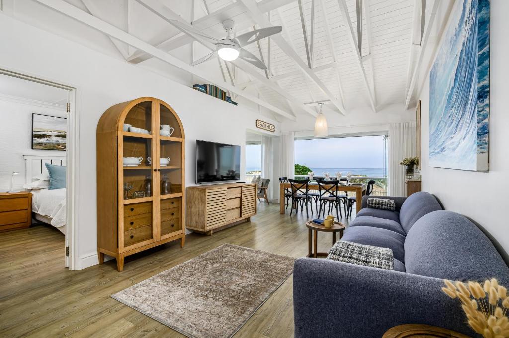 a living room with a blue couch and a tv at Ocean Whisper At 42 in Gqeberha