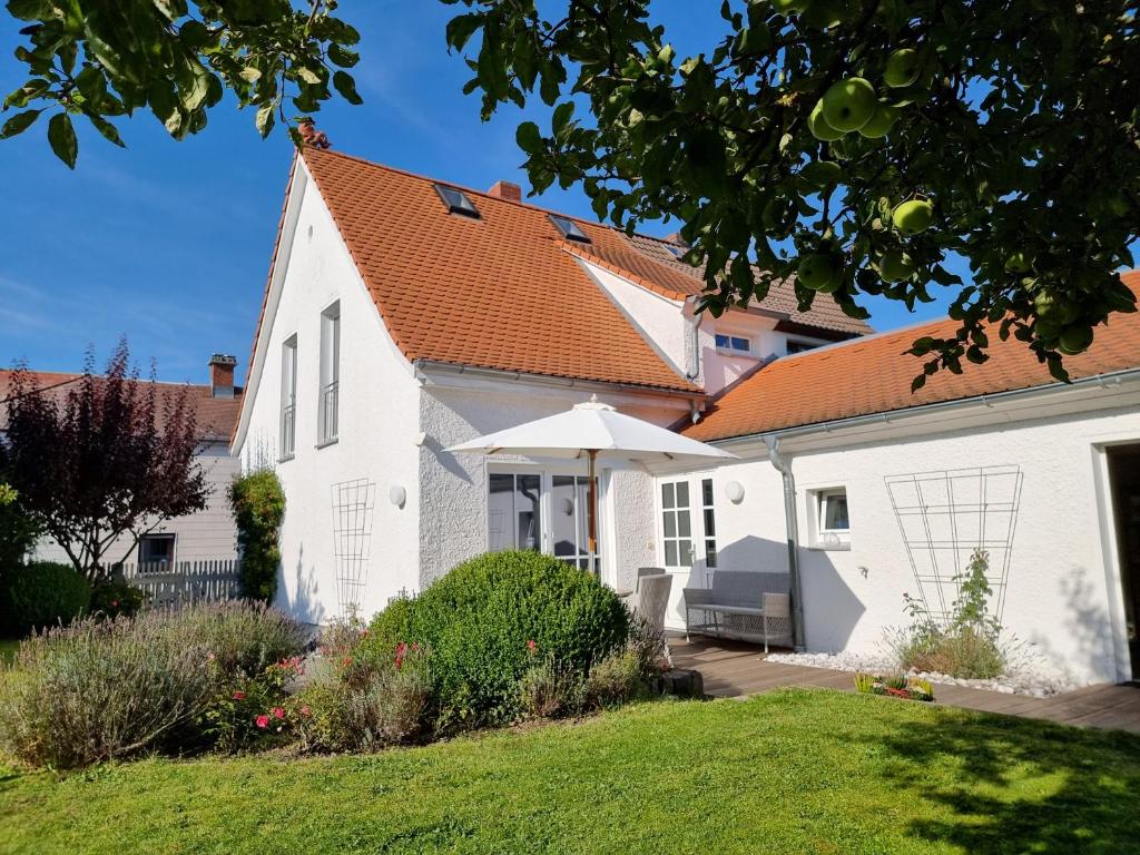 een wit huis met een oranje dak bij Ferienhaus Rosengarten in Selb