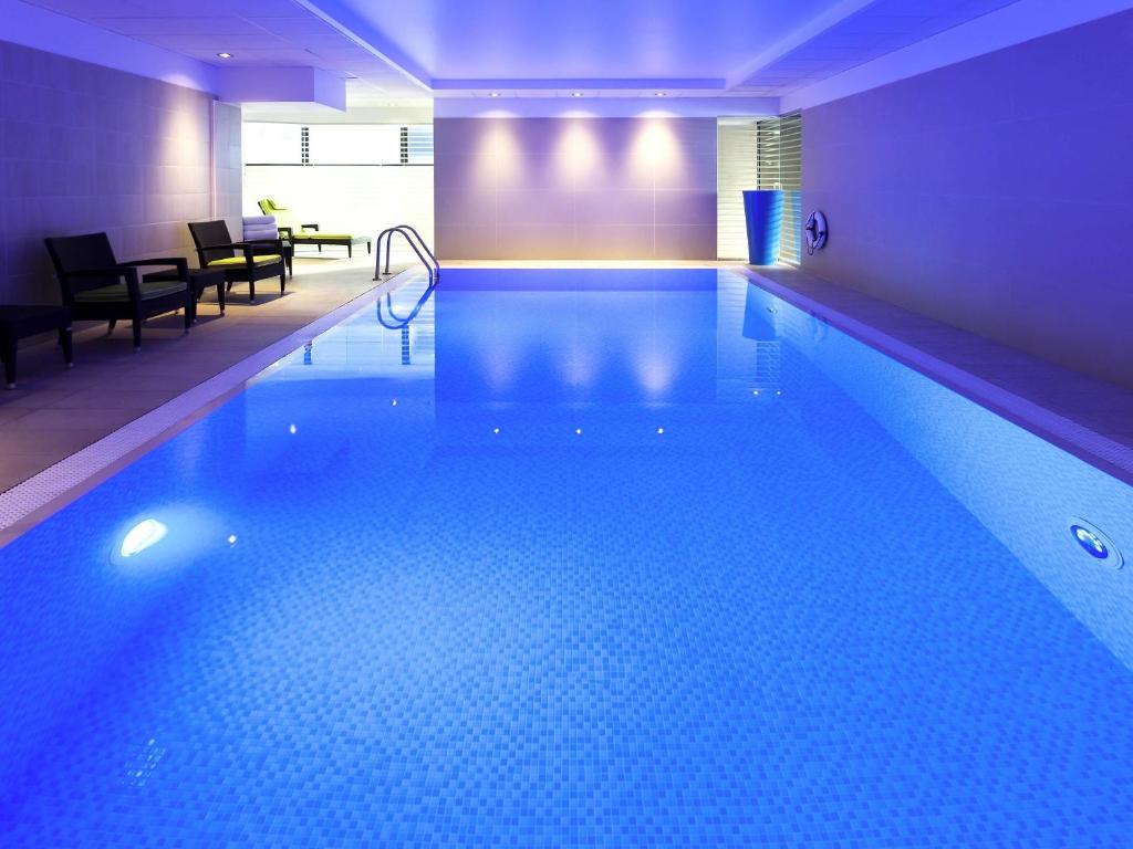 a large swimming pool in a hotel room with at Novotel London Paddington in London