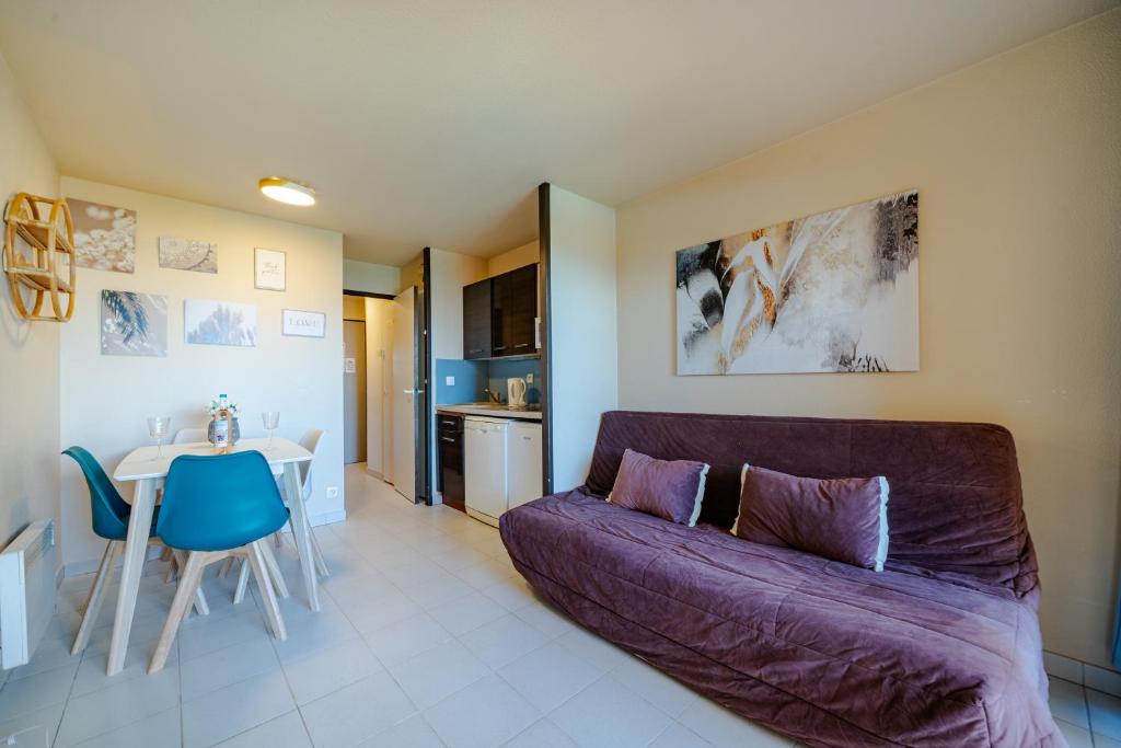 Una sala de estar con un sofá morado y una mesa. en Résidence à Cannes, en Cannes