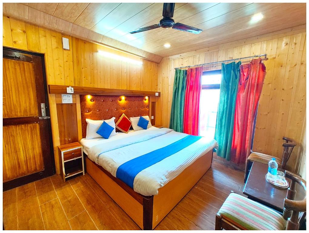 a bedroom with a large bed in a room with wooden walls at Lake View Hotel Chinar Mall Road Nainital - Near NAINA DEVI TEMPLE & NAINI LAKE - FREE WI-FI AND ROOM SERVICE AVAILABLE - PREMIUM HOTEL IN NAINITAL in Nainital
