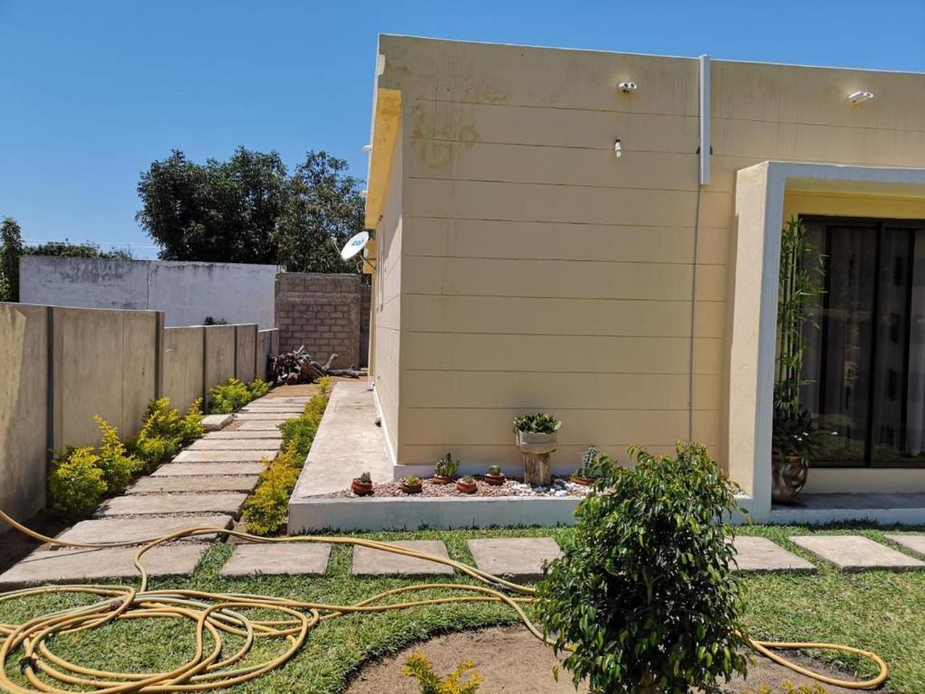 una casa con un jardín con una manguera en Silva house bilene, en Vila Praia Do Bilene