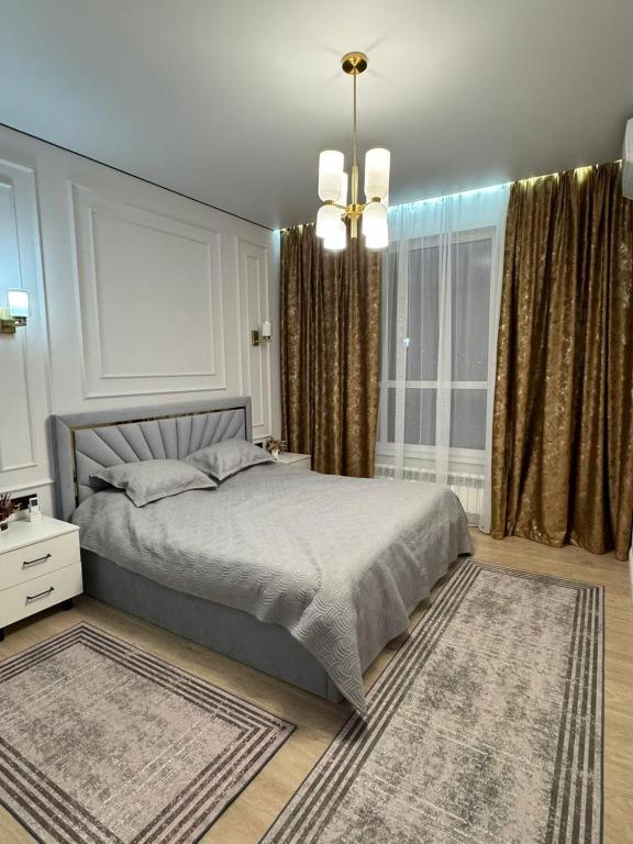 a bedroom with a bed and a large window at Stylish apartment & Perfect choice for Travellers in Almaty