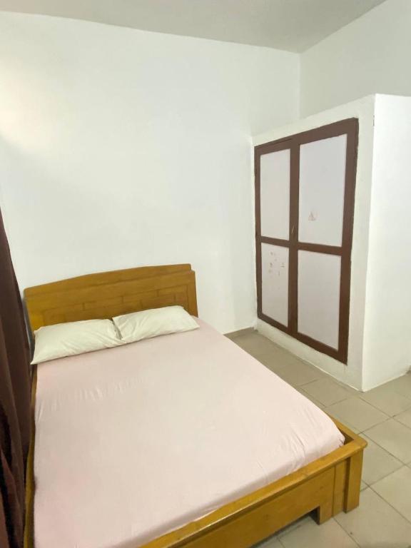 a bed in a room with a window at Maison Calme, Chambre Privée Calavi in Abomey-Calavi
