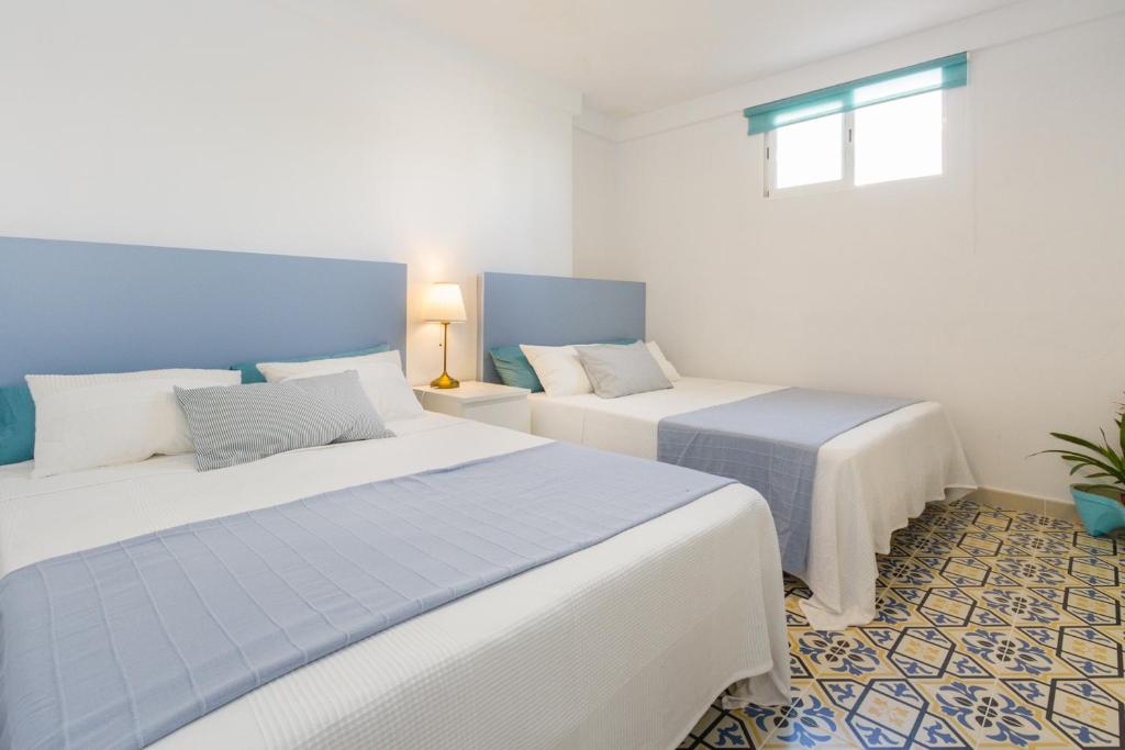 2 camas en una habitación de color azul y blanco en Exclusivo apartamento con piscina privada junto a la playa, en Gandía