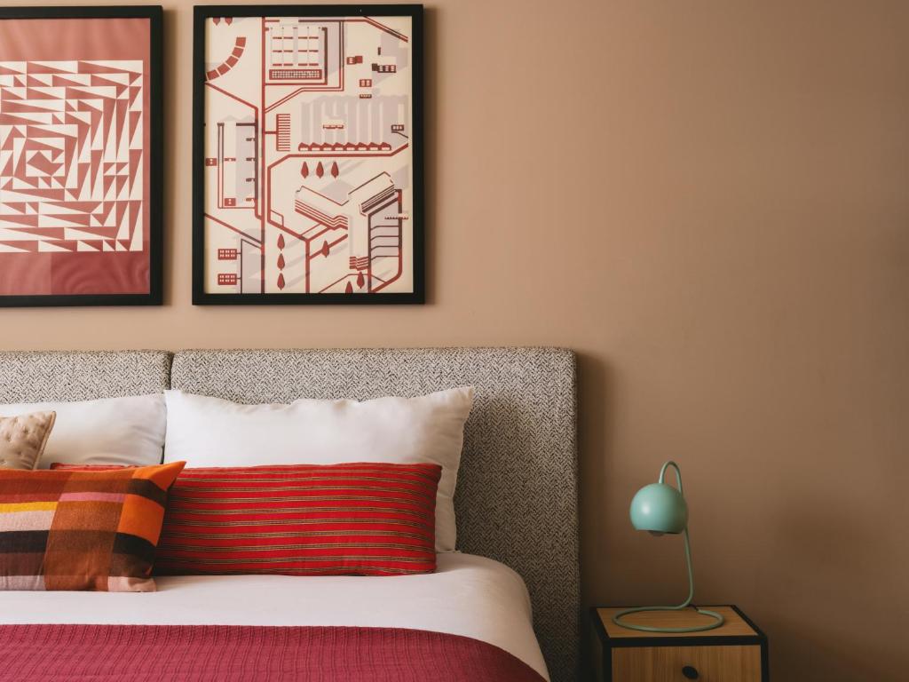 a bedroom with a bed with two framed maps on the wall at Saint J Hotel by Brassbell in Cairo