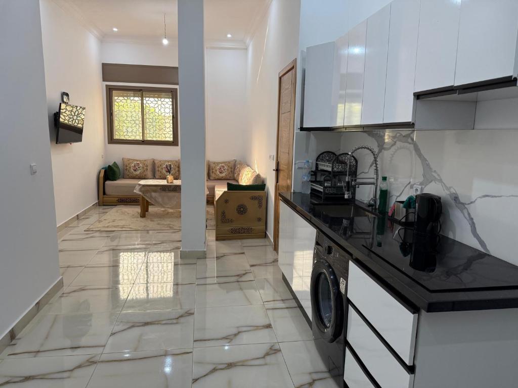 a kitchen with a counter top and a living room at TOP Nour D'asilah in Asilah