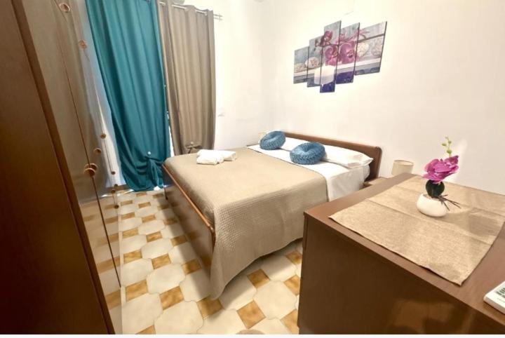 a bedroom with a bed with blue pillows on it at Lavinia House in Oliveri