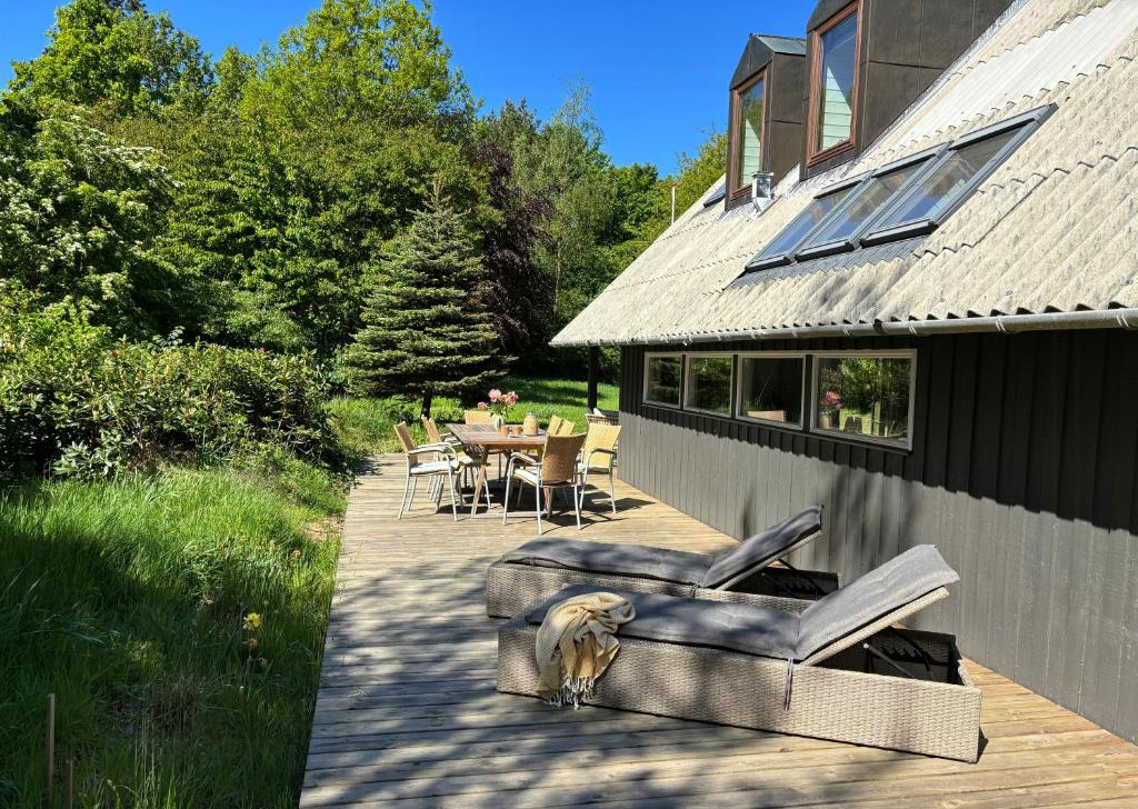 a dog is sitting on a patio next to a house at Hidden Gem By Thy National Park in Bedsted