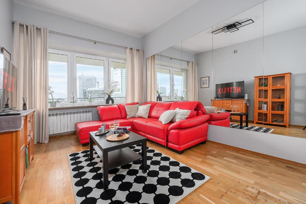 ワルシャワにあるLumina Apart near Palace of Cultureの赤いソファとテーブルのあるリビングルーム