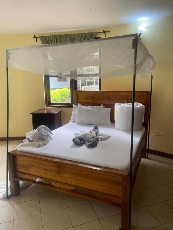 En eller flere senge i et værelse på Emanyatta Lodge