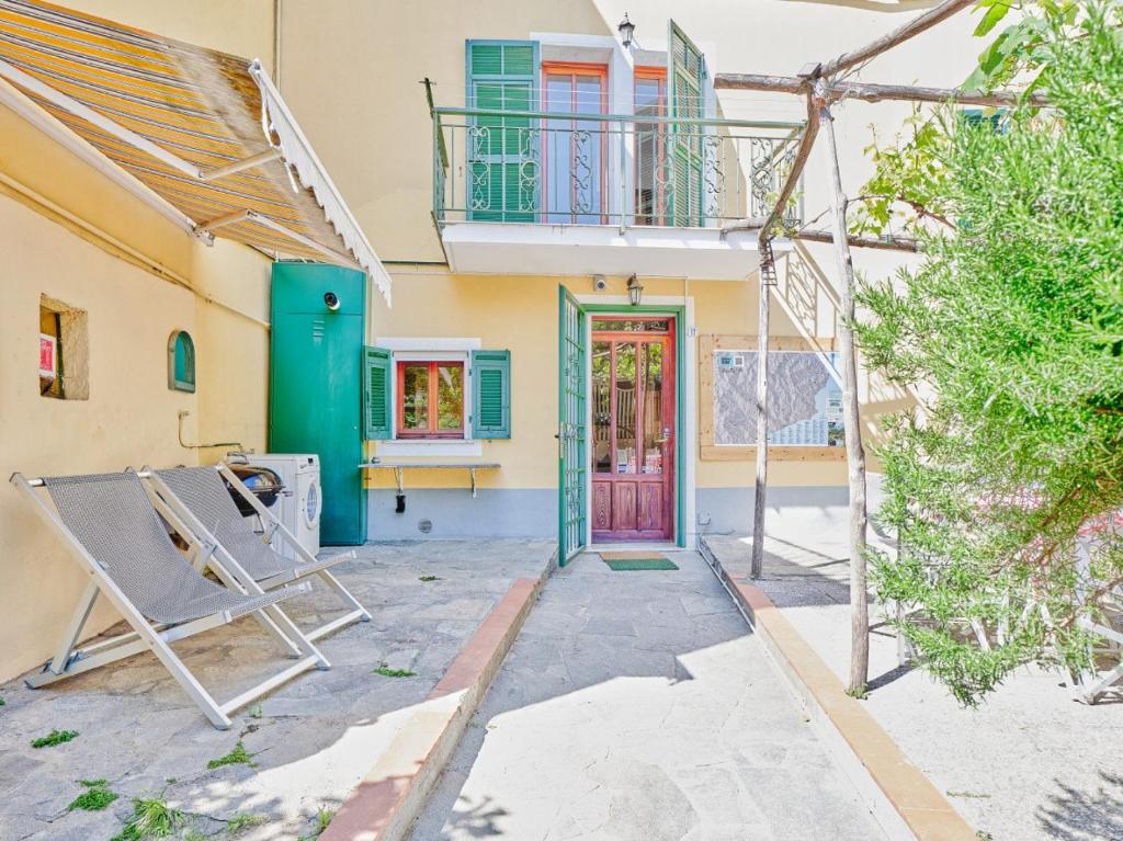une maison avec une porte verte et un balcon dans l'établissement Bright Finalborgo Apartment, à Finale Ligure