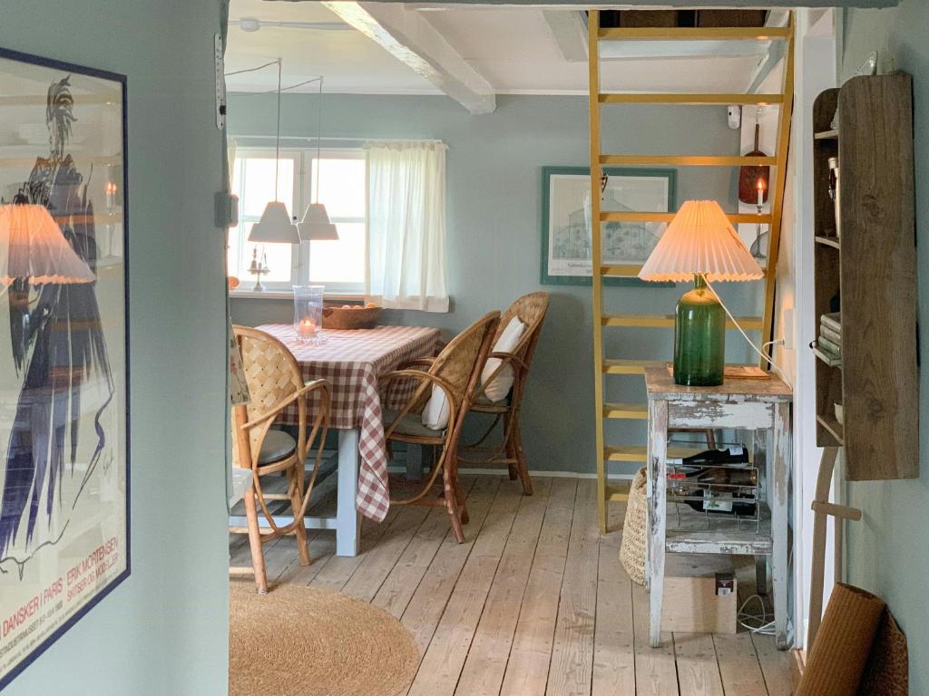 une pièce avec une table et des chaises et une salle à manger dans l'établissement Protected Gem By Glænø's Verdant Woods, à Skælskør